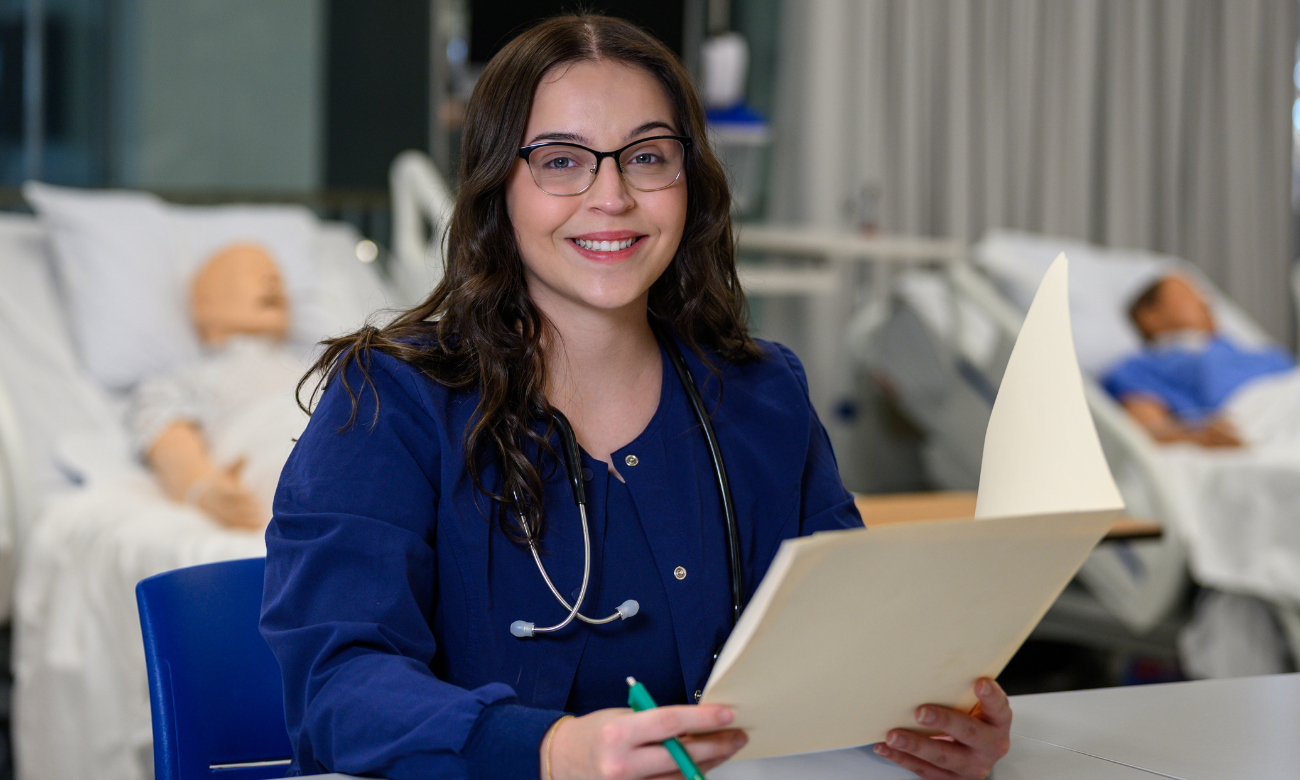 Female student smiling while holding a folder