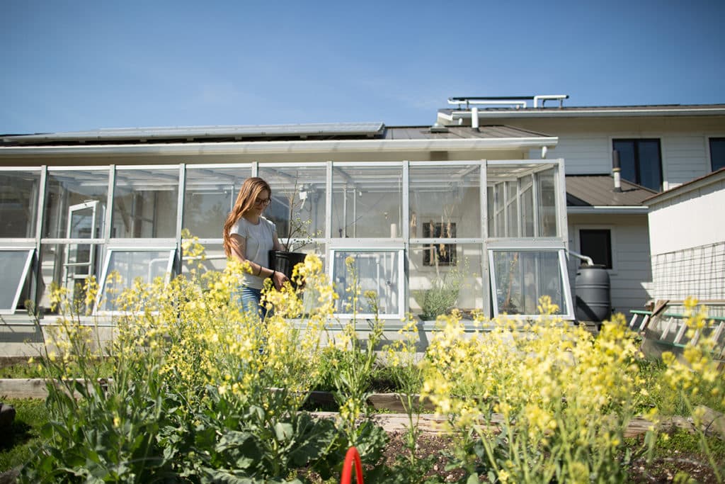 Student carrying a plant at the Ecovillage