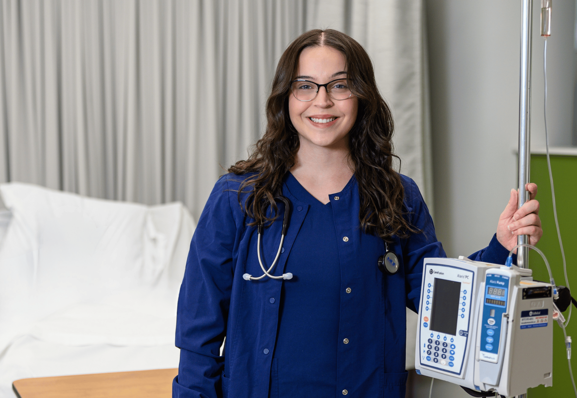 Portrait of student Abbie, holding on to a vital signs machine in the Nursing lab